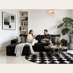 Canapé d'angle velours côtelé noir dans un salon élégant avec tapis graphique