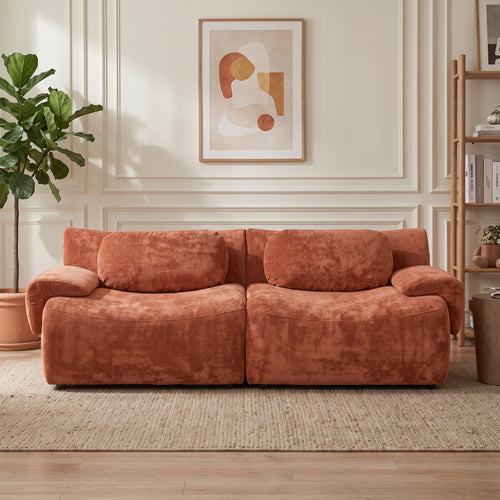 Canapé modulable chenille terracotta dans un salon aux murs moulurés